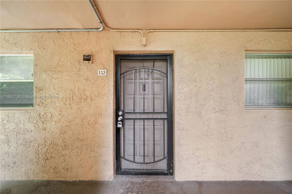 Front view of a building entrance with a metal security door.