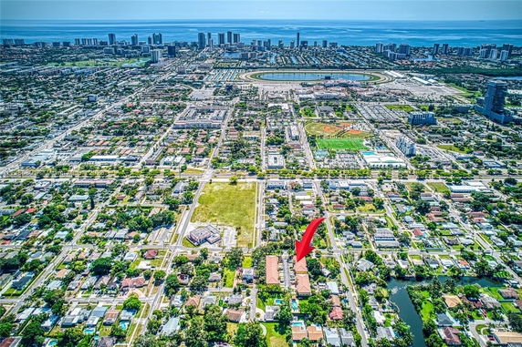 Aerial wide-angle view of a city with residential and commercial areas near the coastline.