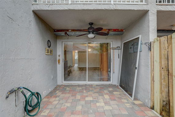 Front view of a house with a tiled patio and sliding glass door.