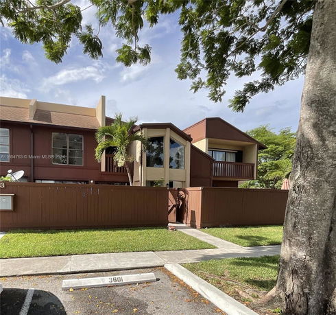 Front view of a two-story townhouse with a fence and balcony.