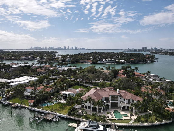 Aerial view of waterfront properties with a city skyline in the background.