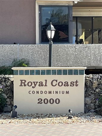 View of the Royal Coast Condominium sign with building in the background.