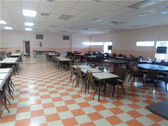 Large indoor area with multiple tables and chairs arranged in rows, suitable for activities or gatherings.