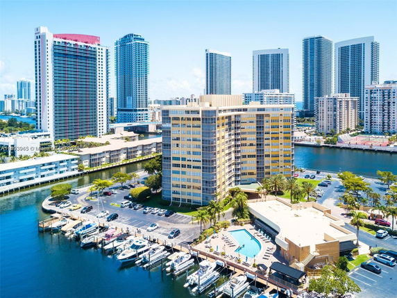 View of multiple high-rise buildings near a waterway, with a marina in the foreground.