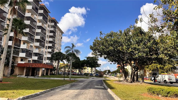 Front view of a multi-story apartment building with balconies.