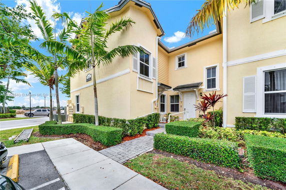 Front view of a two-story house with light yellow exterior and white trim.