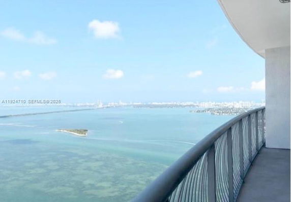 Panoramic view from a balcony overlooking water and distant cityscape.