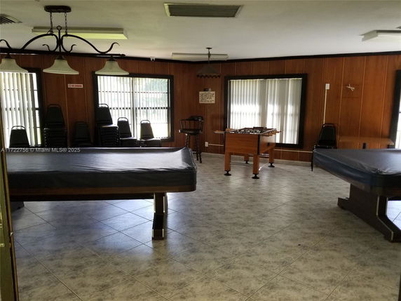 Interior of a recreation room with pool tables and a foosball table.
