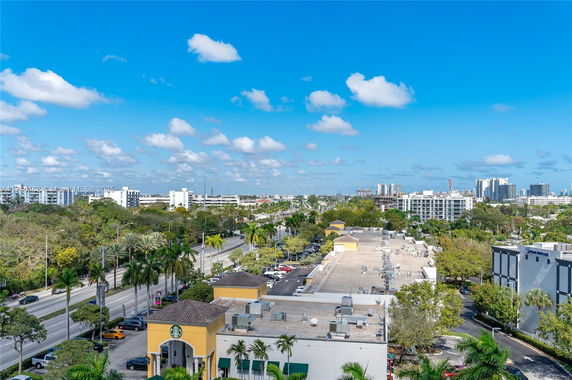 Panoramic view of a cityscape with buildings, roads, and greenery.