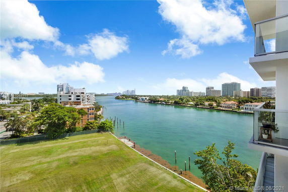 Panoramic view of a waterfront area with buildings, trees, and a waterway.