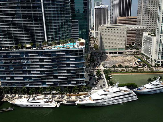 Aerial view of waterfront buildings with yachts docked nearby.
