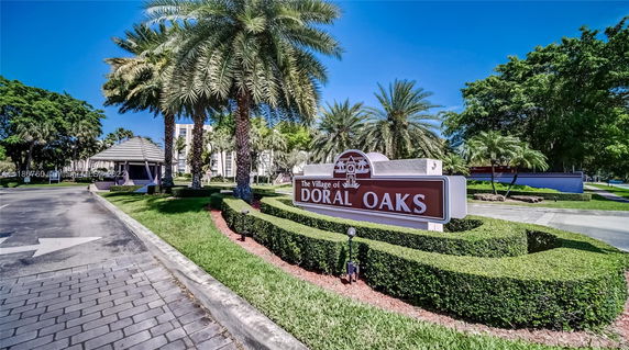 Front view of the entrance to The Village of Doral Oaks, featuring a gated entrance and a landscaped sign.