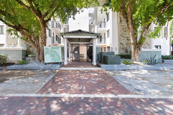 Front view of a multi-story building with a gated entrance.
