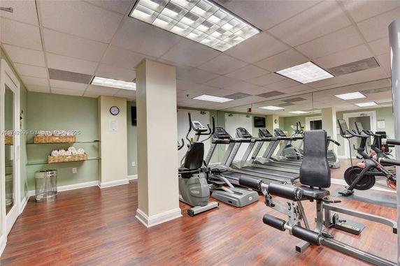 Gym area with exercise equipment and mirrors.