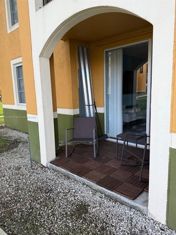 Exterior view of a building with an archway and patio.