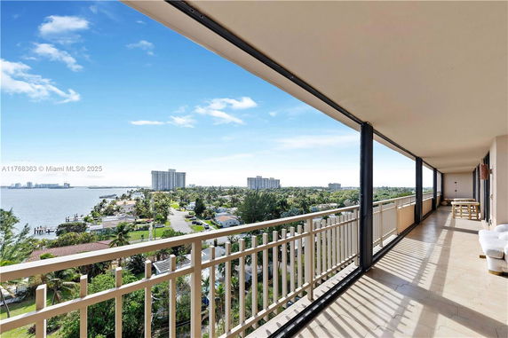 Panoramic view from a high-rise balcony overlooking the ocean and cityscape.