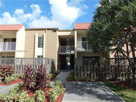 Front view of a two-story building with balconies and a central walkway.