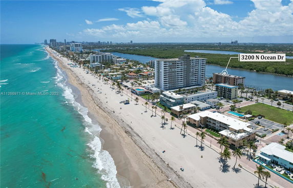 Aerial view of beachfront buildings and ocean shoreline.