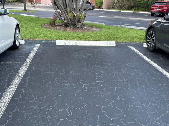Outdoor parking area with designated parking spaces between two cars.