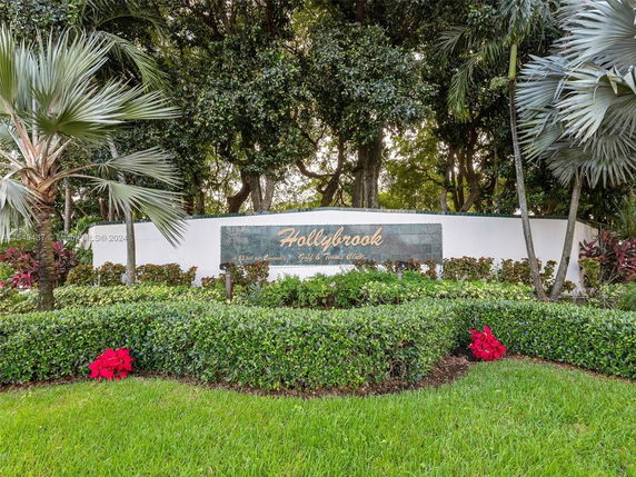 Entrance sign for a place named Hollybrook with surrounding greenery and trees.