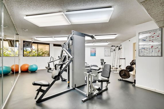 Fitness area with exercise equipment and wellness posters.