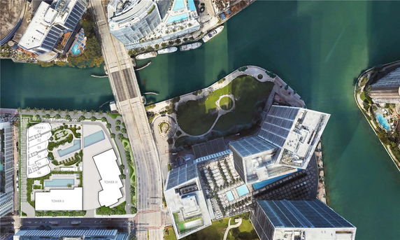 Aerial view of a river, surrounding buildings, and green spaces.