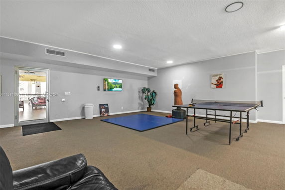 Indoor recreation room with a table tennis setup and exercise mat.