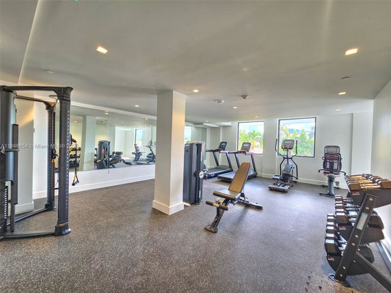 Indoor gym area with various exercise equipment and weights.