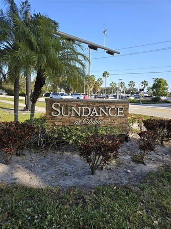 Stone sign with the text 'Sundance at Davie' surrounded by plants.