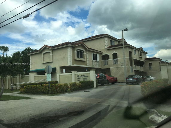 Front view of a multi-story residential building with terracotta roof tiles.