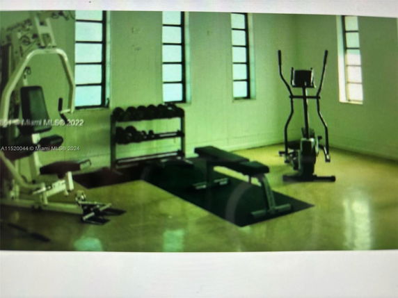 Indoor gym area with exercise equipment and weights.