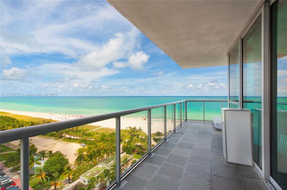 Panoramic view from a balcony overlooking the ocean and beach.