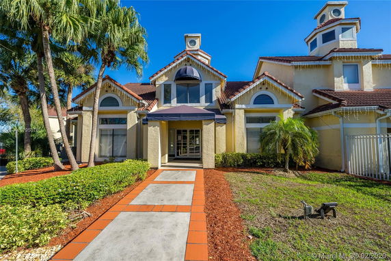 Front view of a house with a prominent entrance and decorative windows.