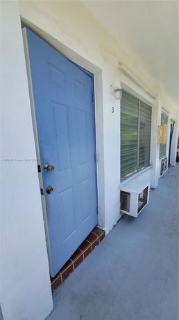 Front view showing a blue door and windows of a building unit.