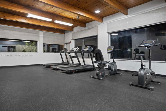 Indoor gym area with exercise equipment including treadmills and stationary bikes.