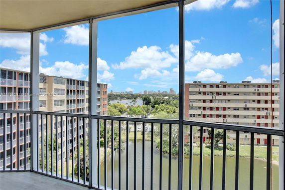 View from a balcony showing nearby residential buildings and a pond.