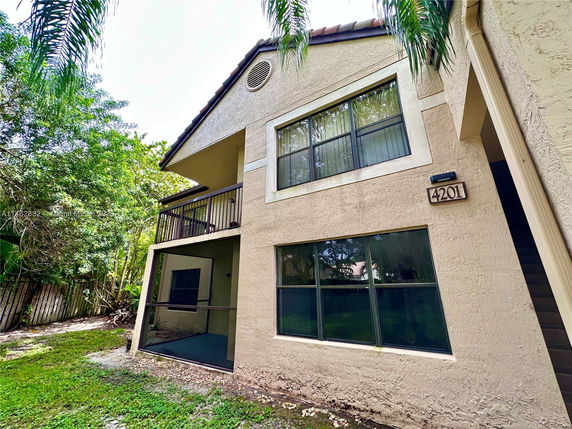 Front view of a two-story house with large windows and a balcony.