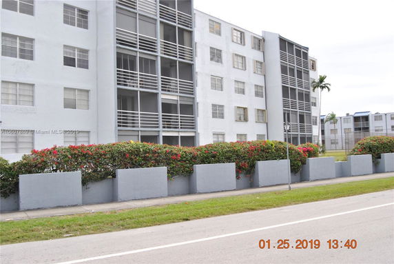 Front view of a multi-story apartment building with balconies.