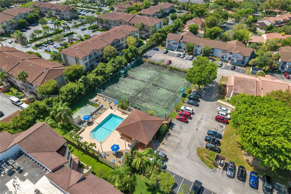 Aerial view of residential complex with swimming pool and tennis court.