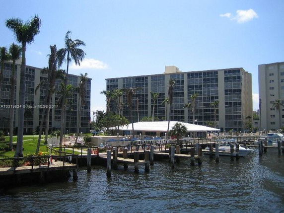 View of several mid-rise apartment buildings near a waterfront with docks and boats.