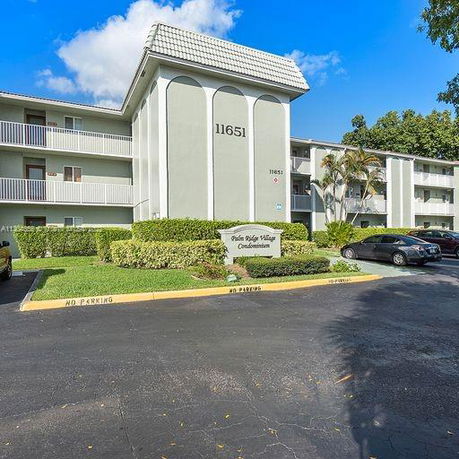 Front view of a condominium building with multiple stories and balconies.