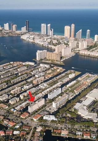 Aerial view of a coastal urban area with numerous high-rise buildings near the waterfront.