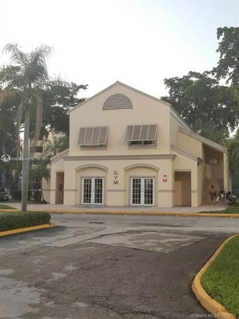 Front view of a two-story gym building with arched windows.