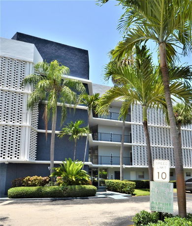 Front view of a multi-story building with balconies and decorative facade.