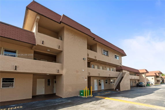 Front view of a multi-story apartment building with external staircases.