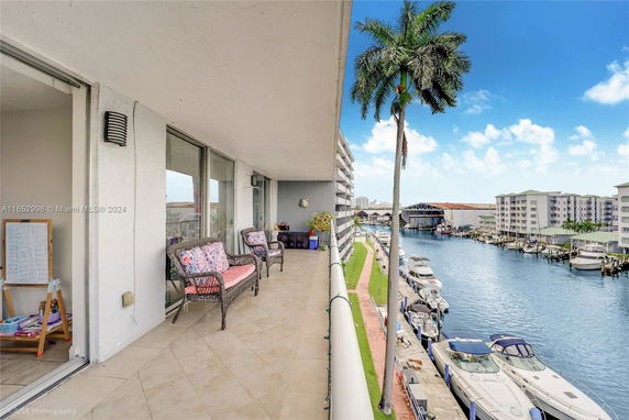 Balcony view from an apartment overlooking a canal with boats and nearby buildings.