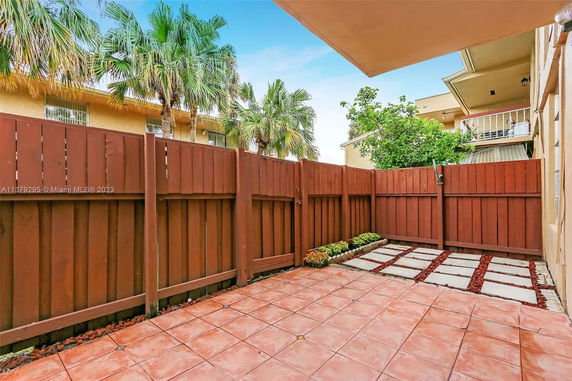 Fenced outdoor area with tile and stone paving.
