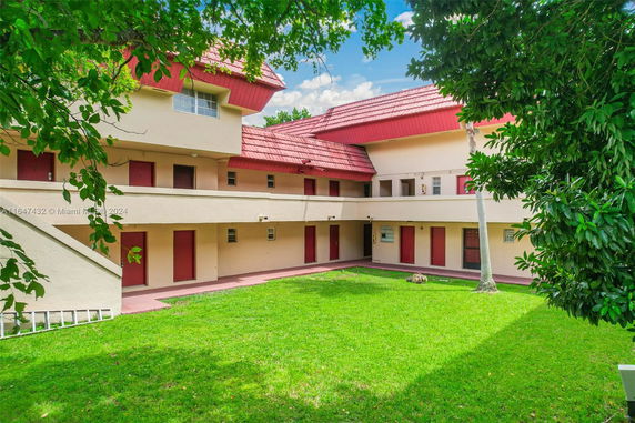 Front view of a two-story building with red roofs and multiple entrances.