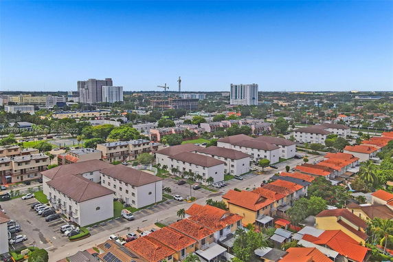 Aerial panoramic view of a residential area with buildings and high-rises in the background.