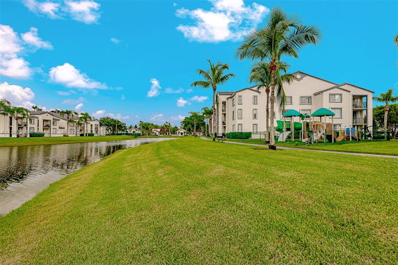 Landscape view of apartment buildings with an outdoor play area by a canal.